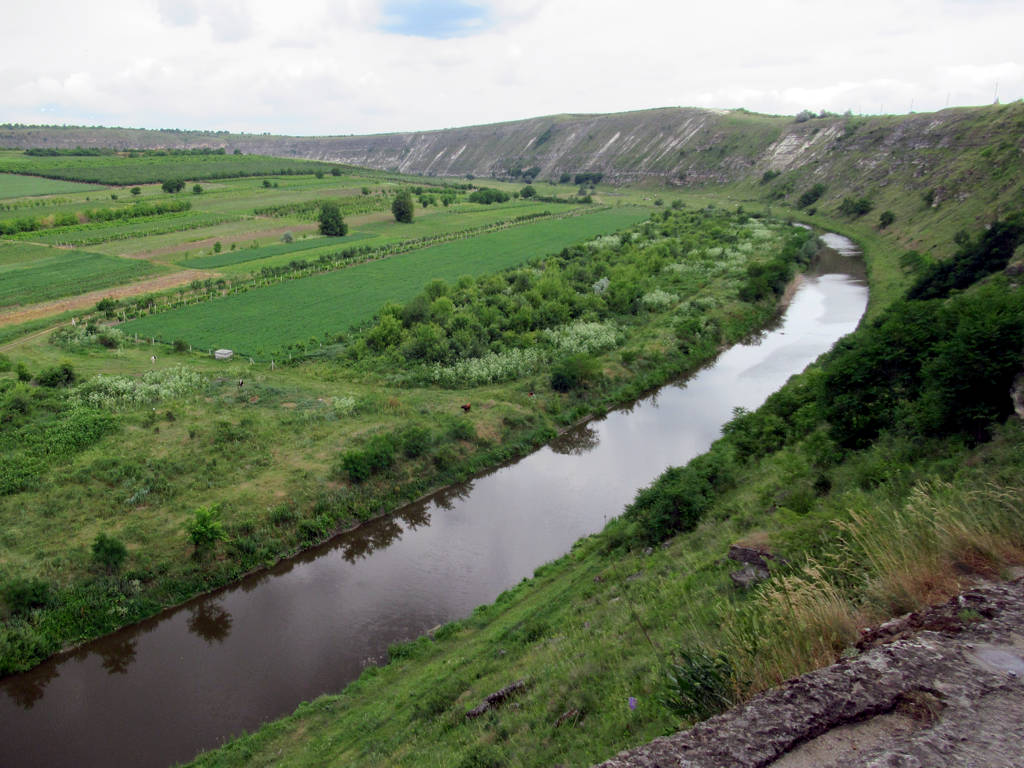 Cliffs above the Răut river at Orheiul Vechi, with fields and the winding river below